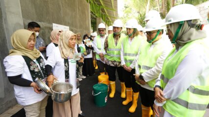 Behavior Change Campaign volunteers explaining the importance of household waste separation